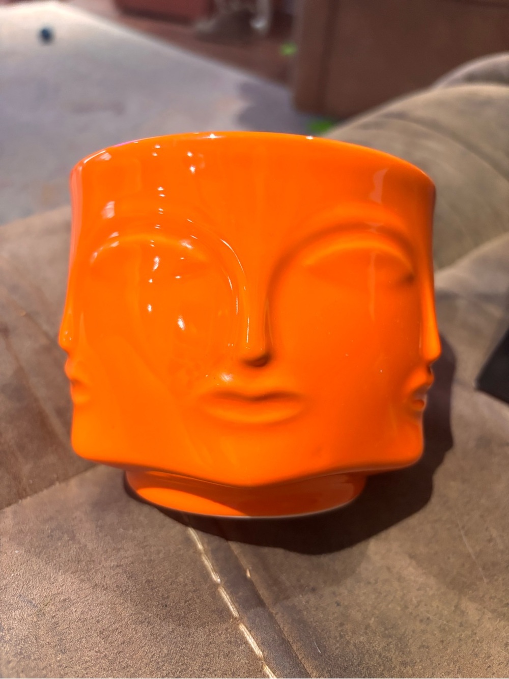 Aromatherapy Candle - Orange container with faces on each side.